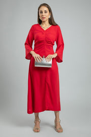 فستان نسائي طويل بلون موحد وخامة ناعمة مع تفاصيل طيّات أمامية