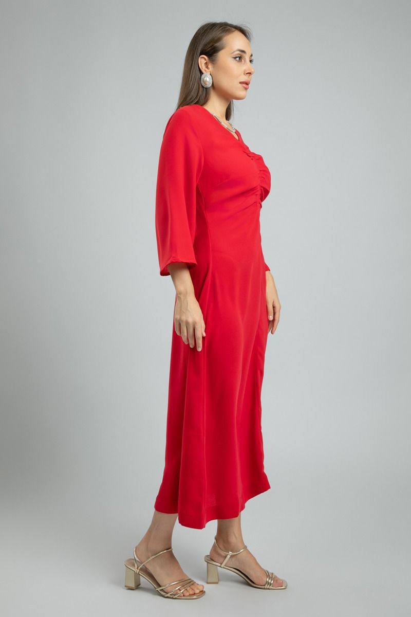 فستان نسائي طويل بلون موحد وخامة ناعمة مع تفاصيل طيّات أمامية