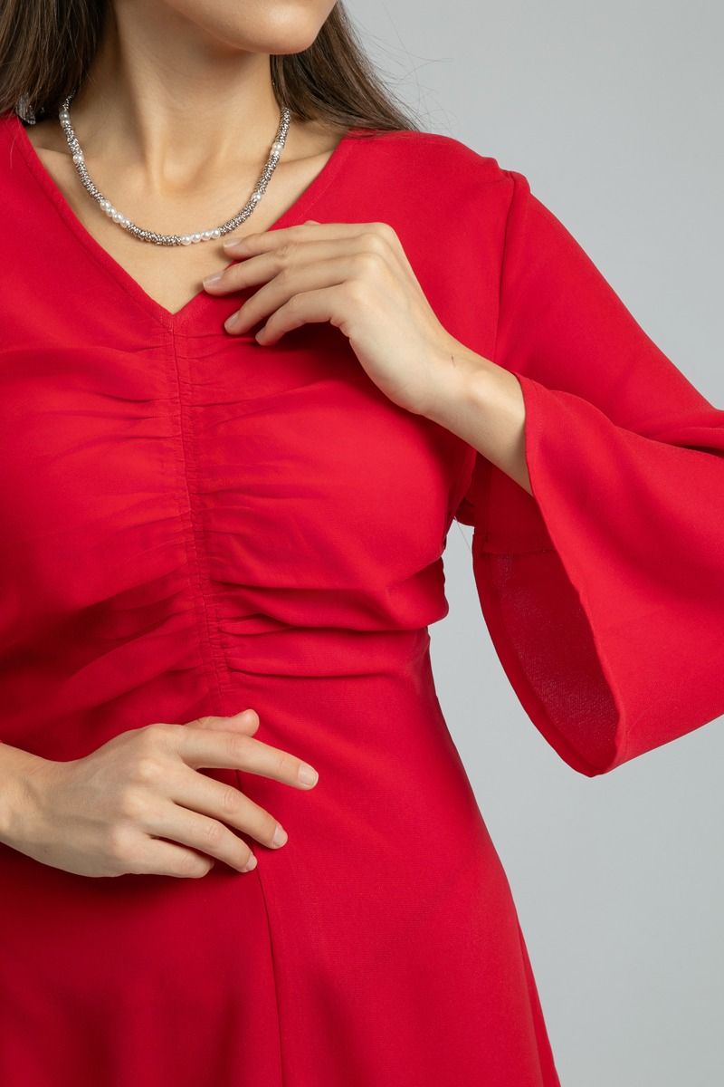 فستان نسائي طويل بلون موحد وخامة ناعمة مع تفاصيل طيّات أمامية